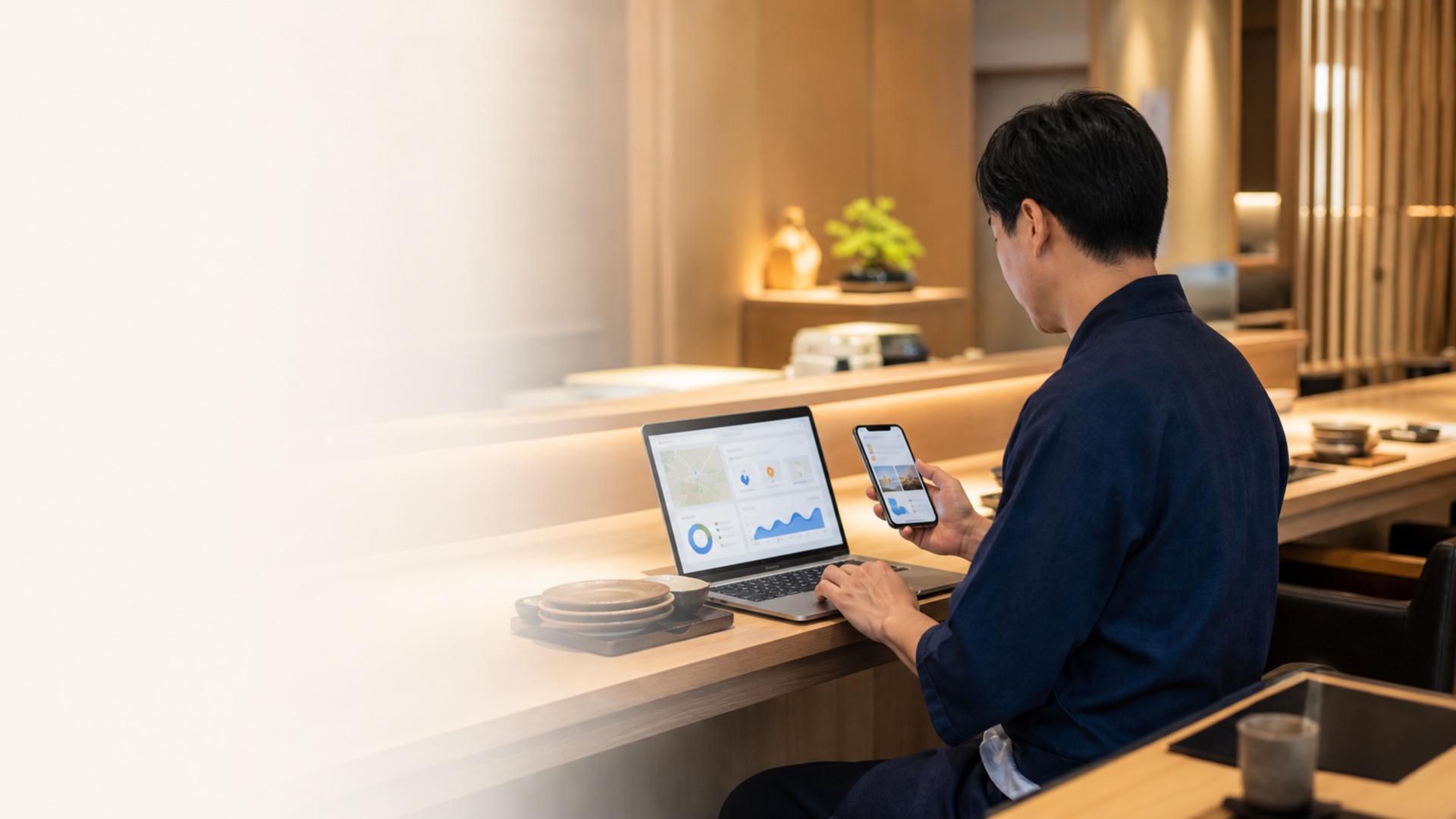 飲食店のカウンターでGoogleマップと分析画面を確認する店主